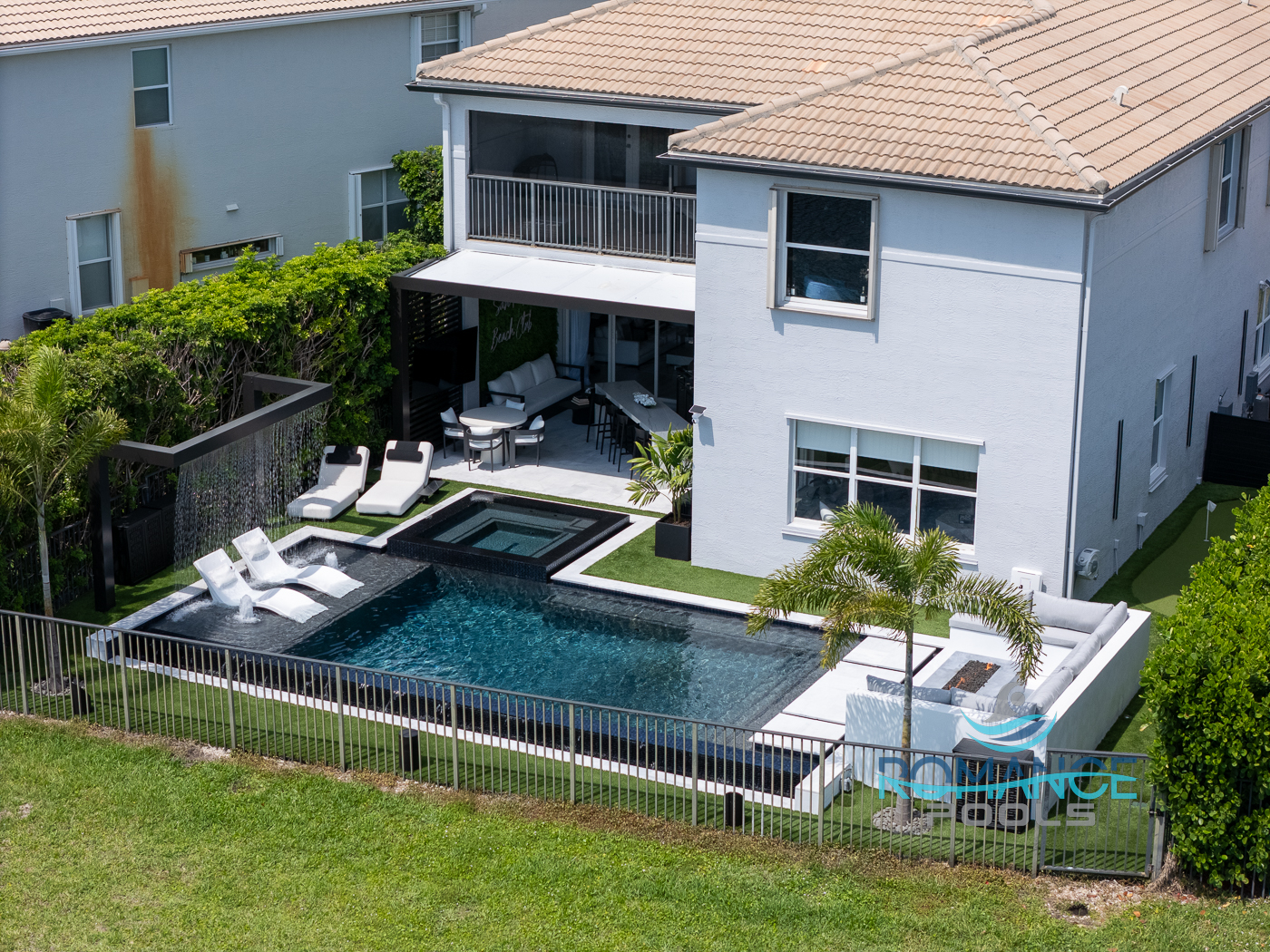 Contemporary swimming pool and spa with outdoor living area, seating space, and stylish backyard design by Romance Pools